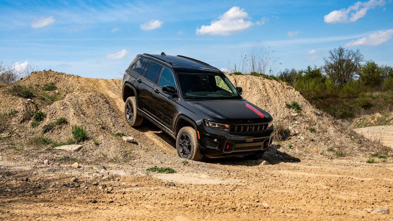 3/4 front and side view of the 2027 Jeep Grand Cherokee Trailhawk on a steep sand dune