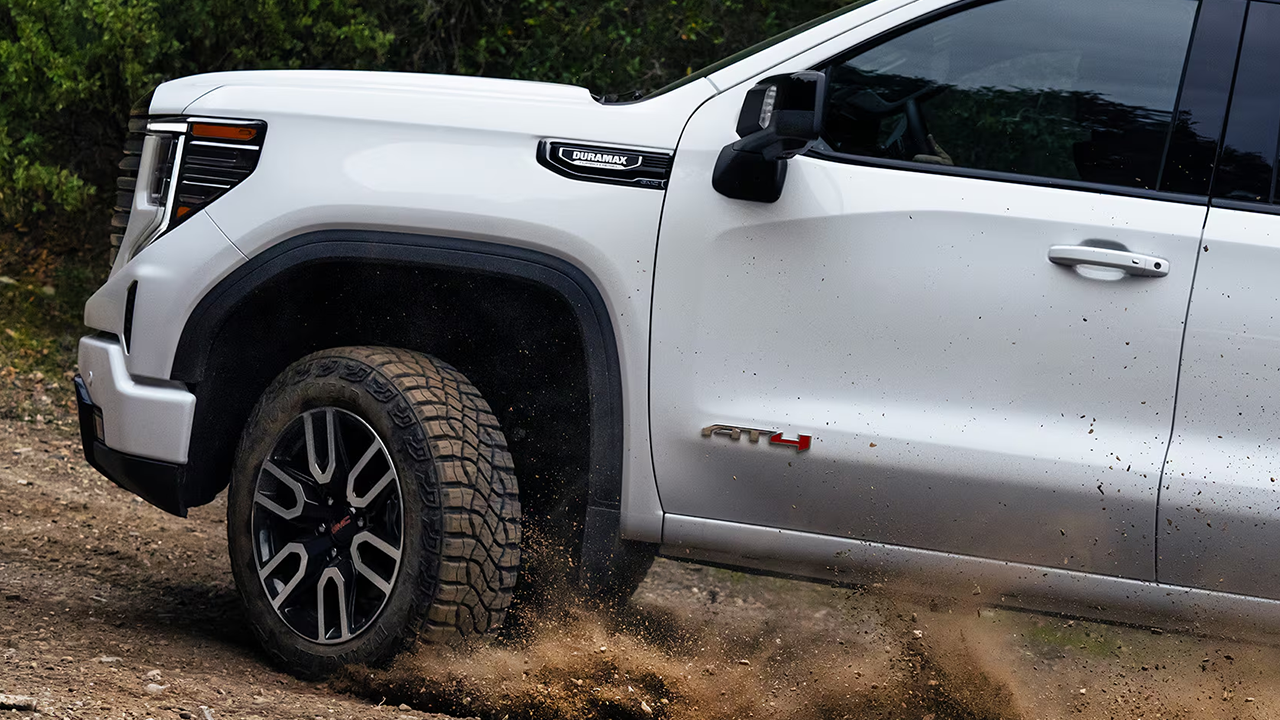 3/4 front and side view of the 2026 GMC AT4 powering up a steep trail