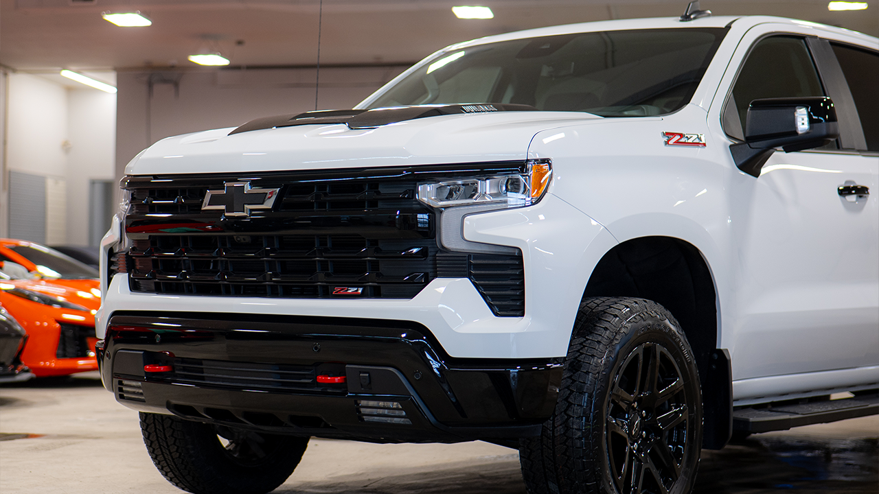 Vue lat&eacute;rale du Chevrolet Silverado 2026 blanc dans le garage du concessionaire Paill&eacute;
