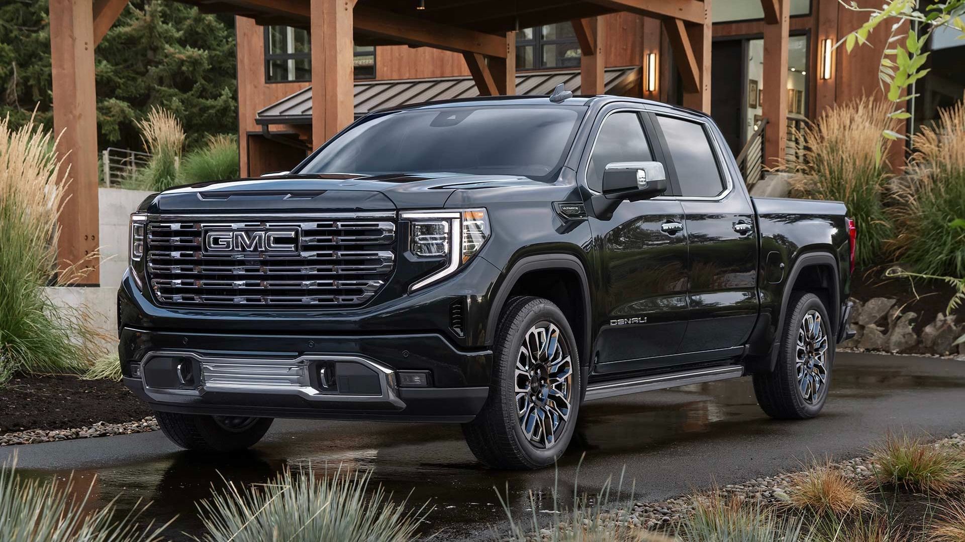 A GMC Sierra 1500 Denali parked in front of a home.