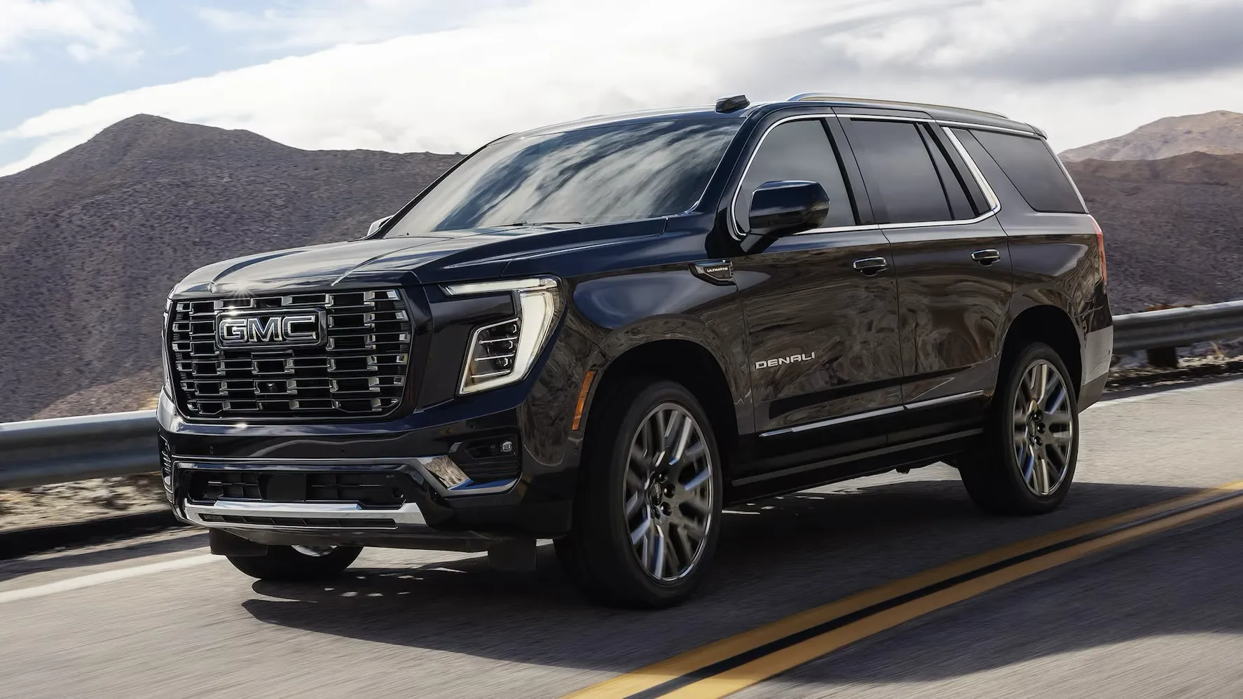 Side view of the black 2026 GMC Yukon XL on the road
