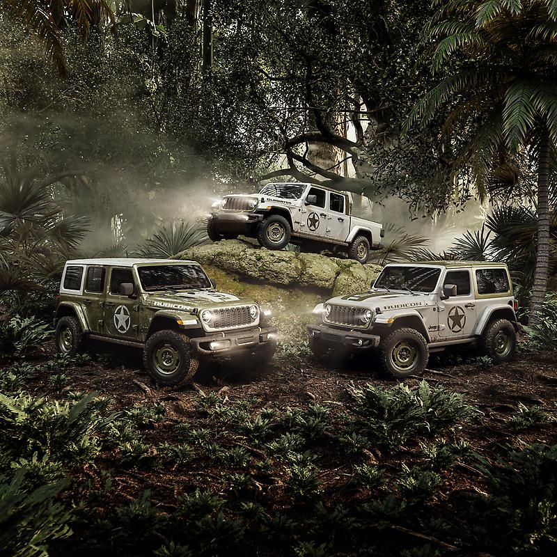 Three Jeep Wrangler Sarge trucks off-roading through mud and forest.