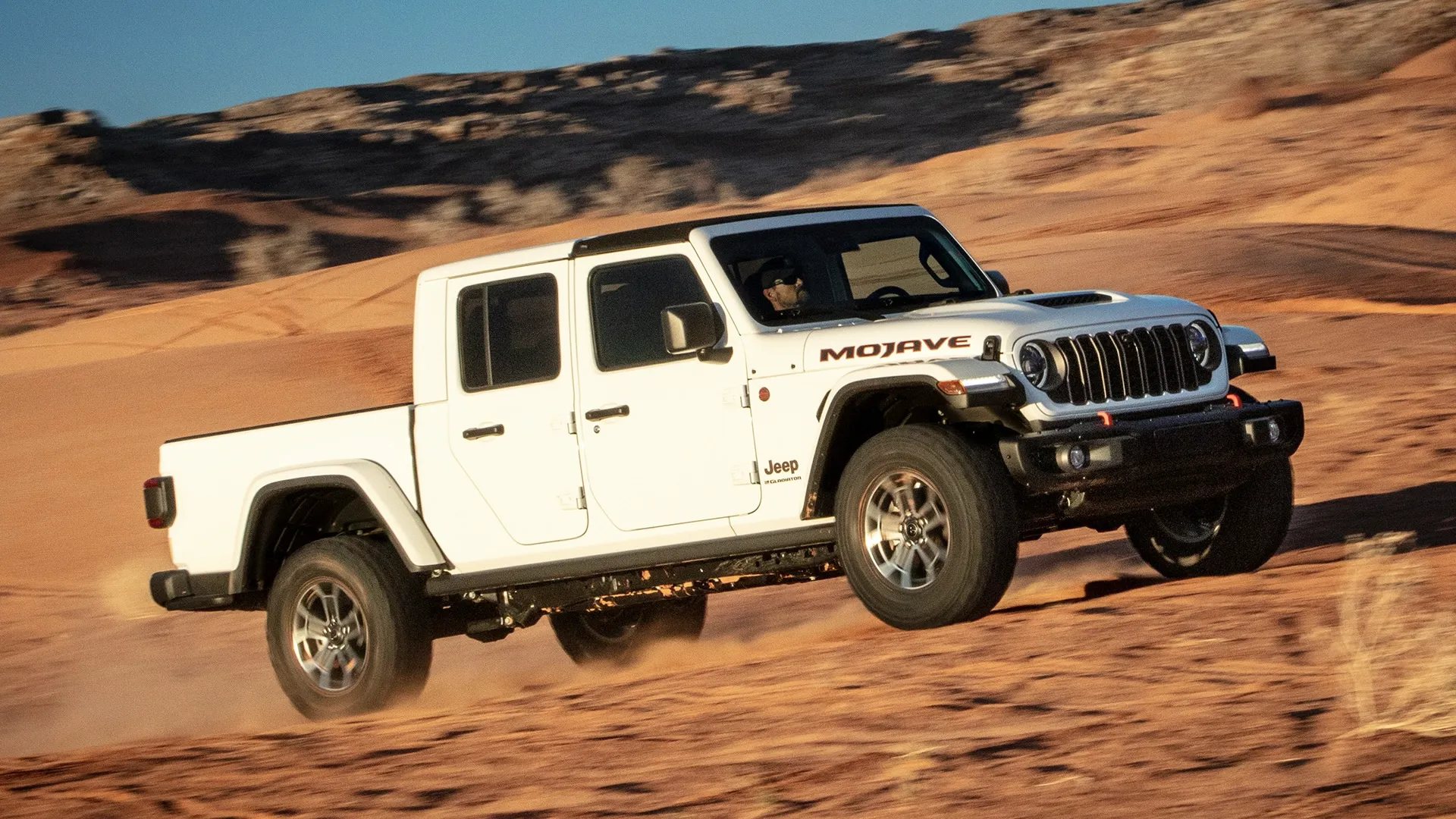 White Jeep Gladiator Mojave off-roading in the sand.