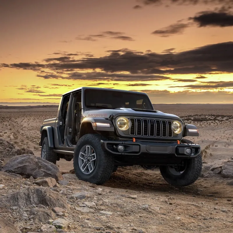 Jeep Gladiator Mojave driving on a dirt road at sunset.