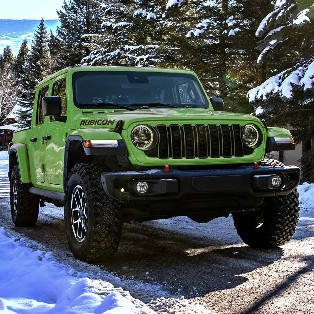 Green Jeep Gladiator Rubicon in the snow, ready for off-roading.