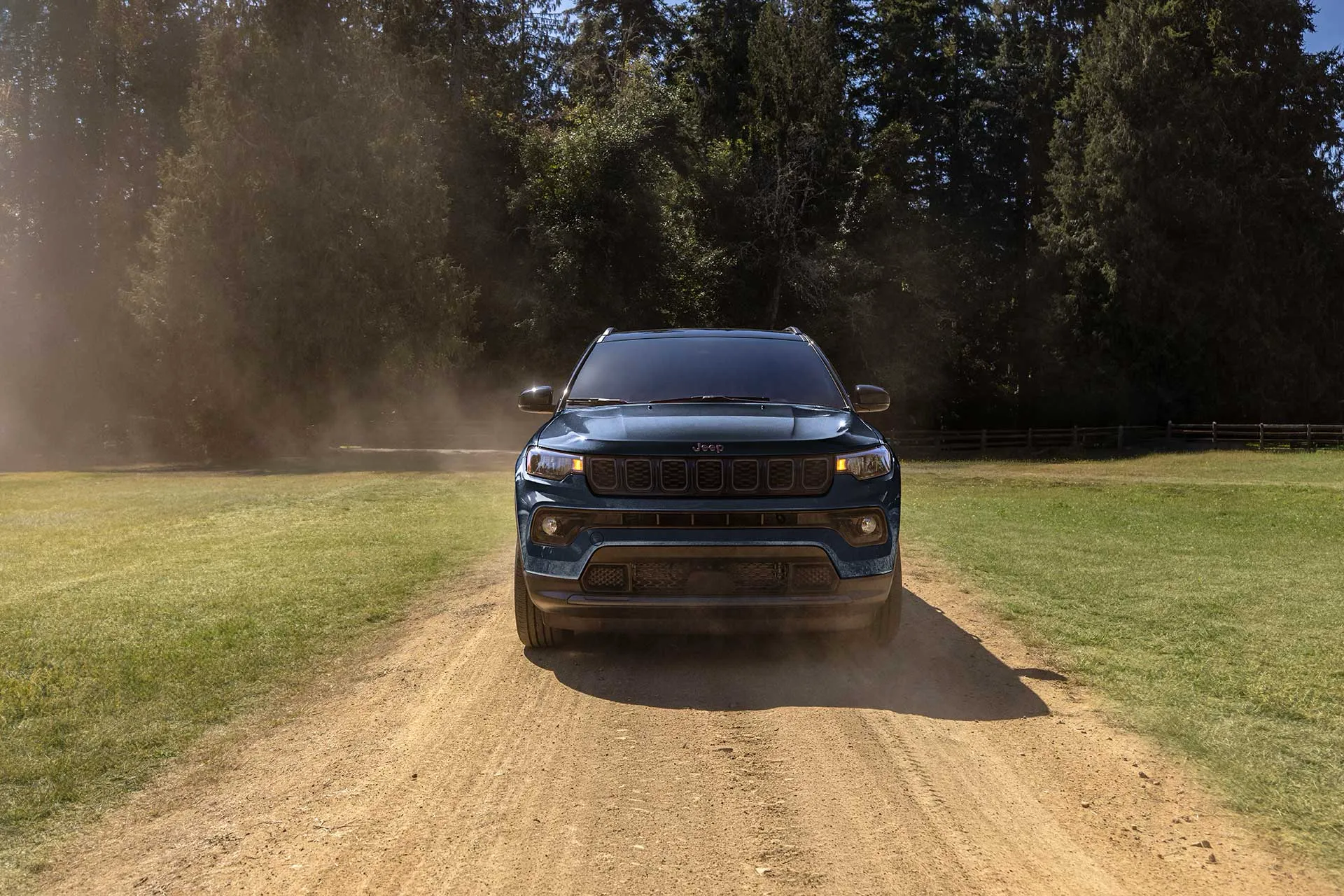 2027 Jeep Compass on a dirt road at sunset.