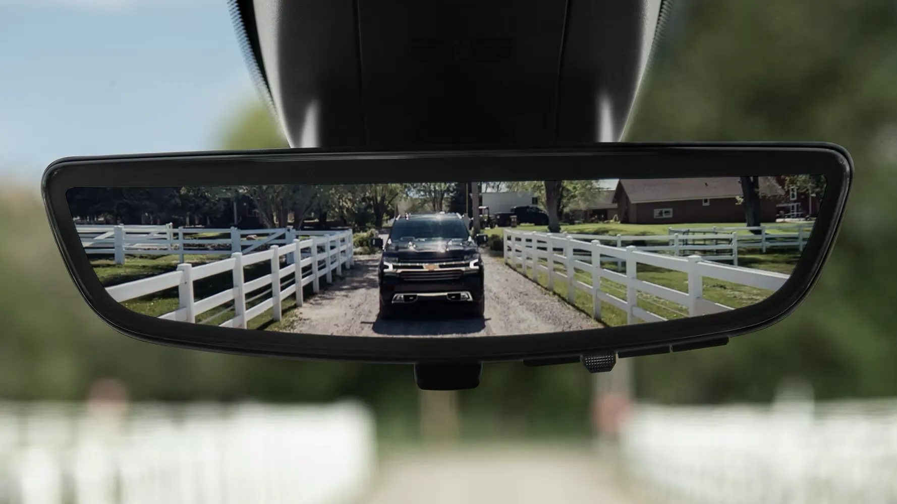 R&eacute;troviseur int&eacute;rieur en mode cam&eacute;ra affichant la vue arri&egrave;re d'un camion GM sur la route.