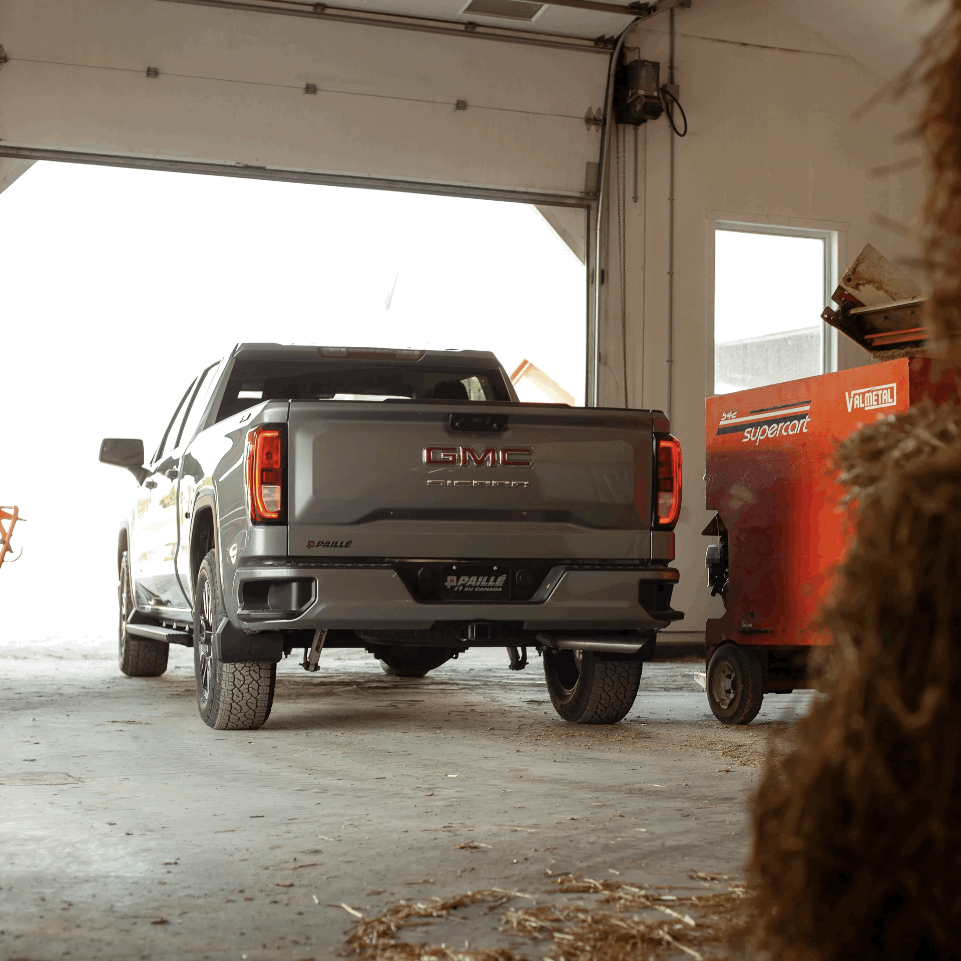Camion GMC Sierra recul&eacute; devant un garage r&eacute;sidentiel, pr&ecirc;t &agrave; &ecirc;tre charg&eacute;.