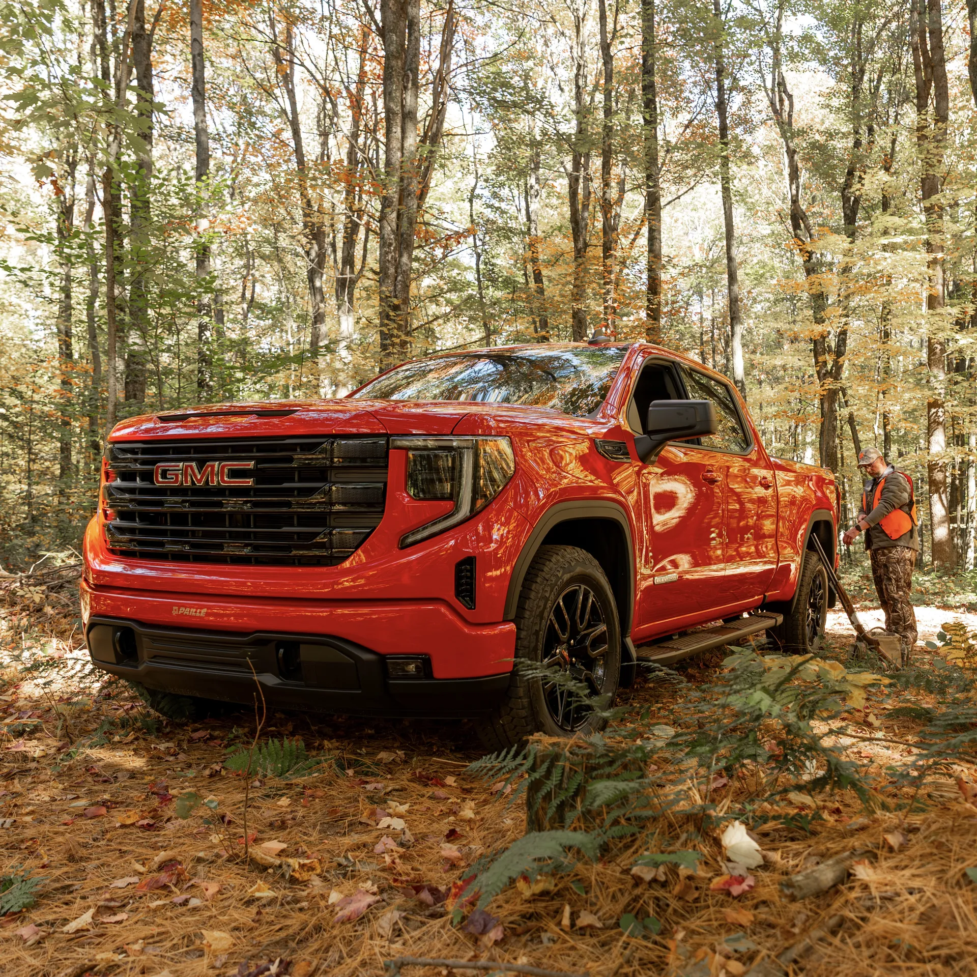 GMC Sierra 1500 2027 rouge vu de l'avant dans un sous-bois d'automne