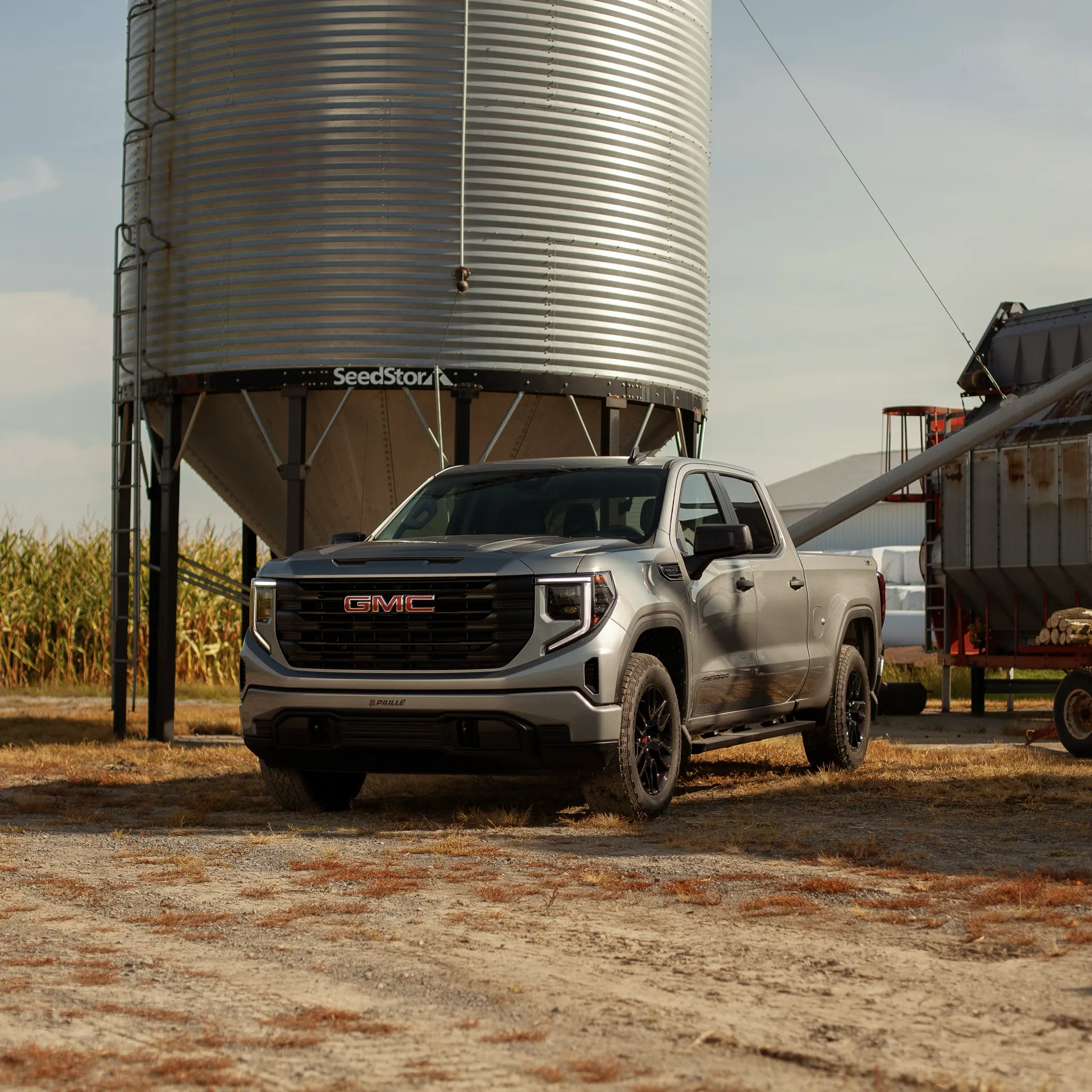 GMC Sierra 1500 2027 gris stationn&eacute; pr&egrave;s d'un silo &agrave; la ferme