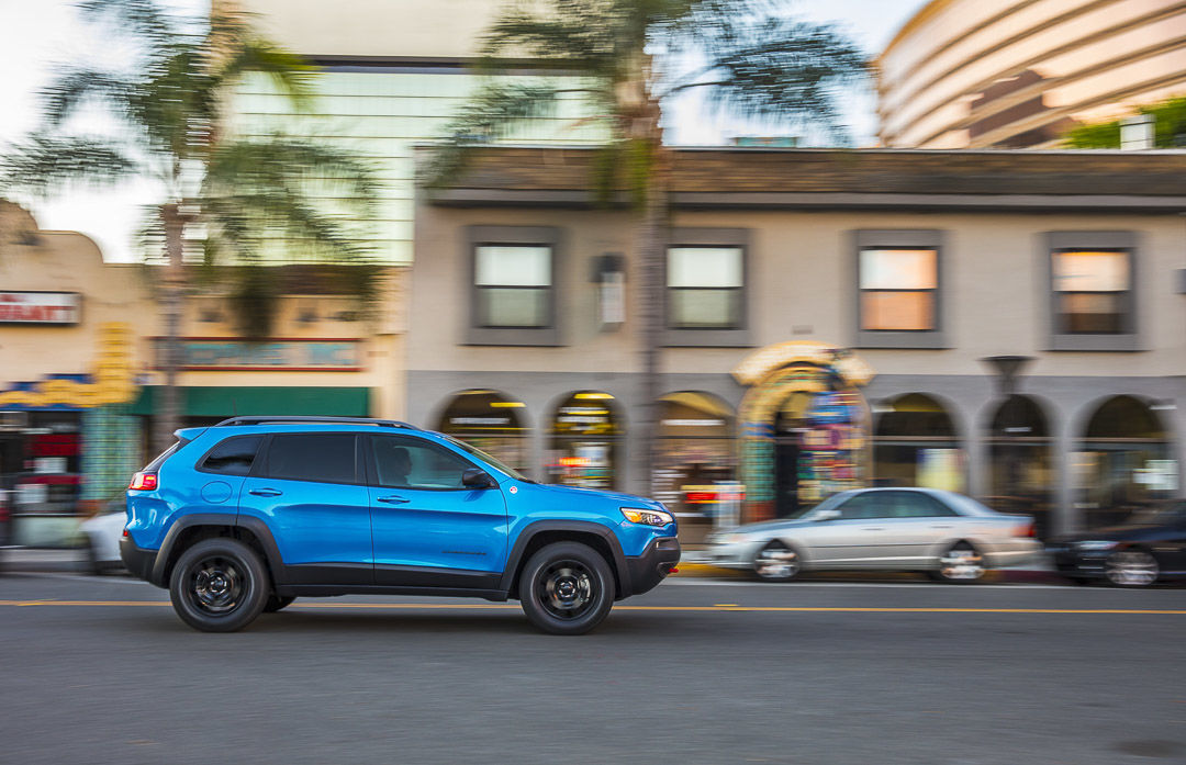 Side view of the 2022 Jeep Cherokee Trailhawk powering through town.