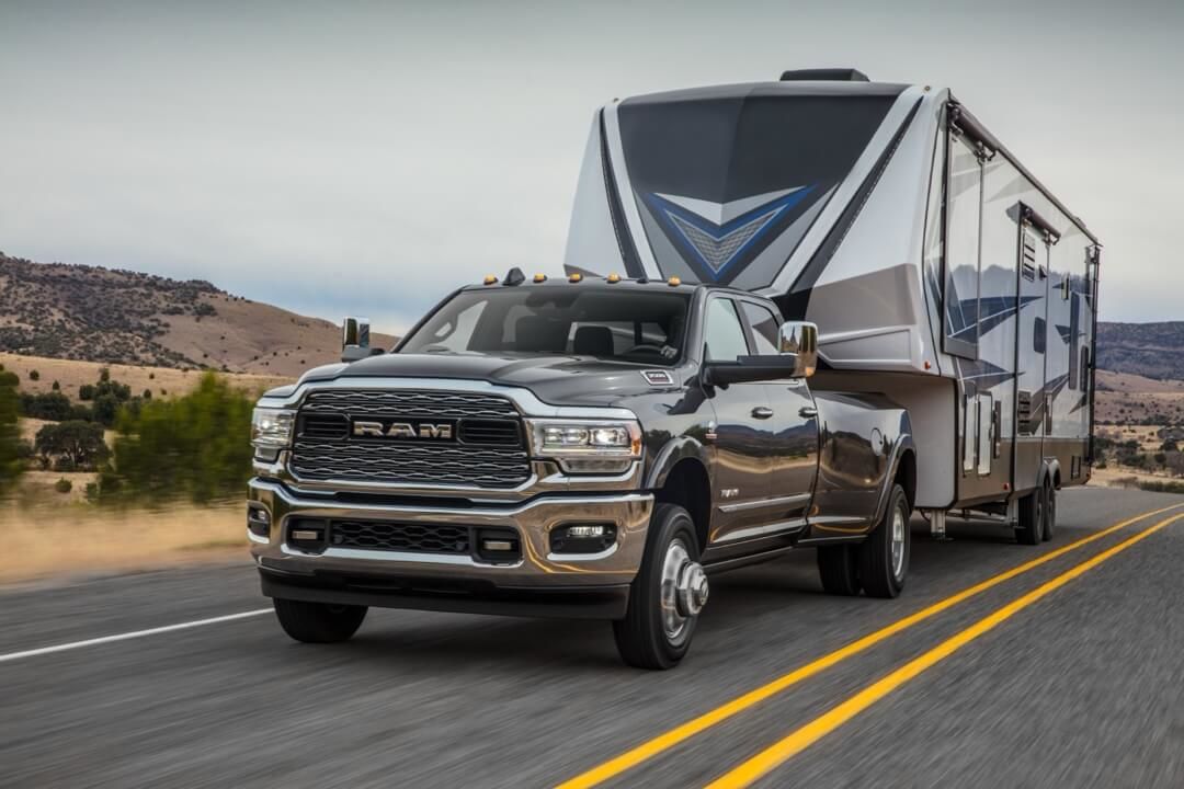 3/4 front view of the 2024 RAM 3500 HD Limited towing a fifth wheel trailer.
