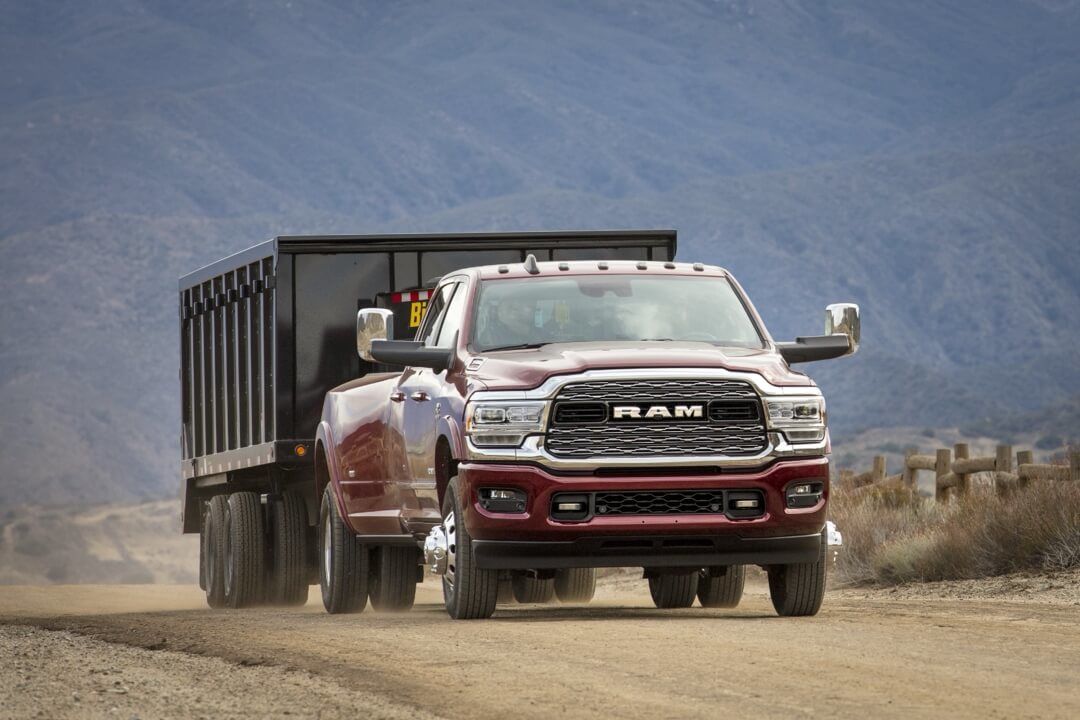 3/4 rear view of the 2024 RAM 3500 HD Limited towing a cargo.