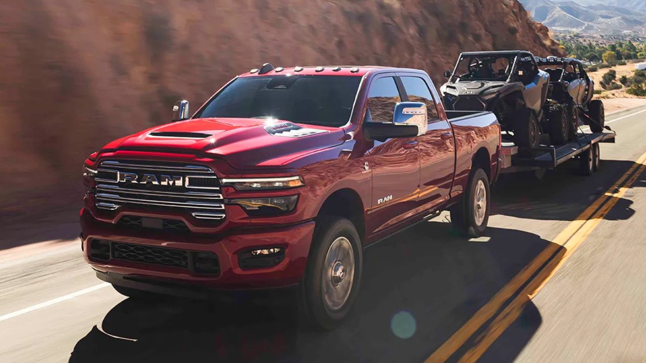 vue latérale avant d'un ram 1500 2026 remorquant des side by side
