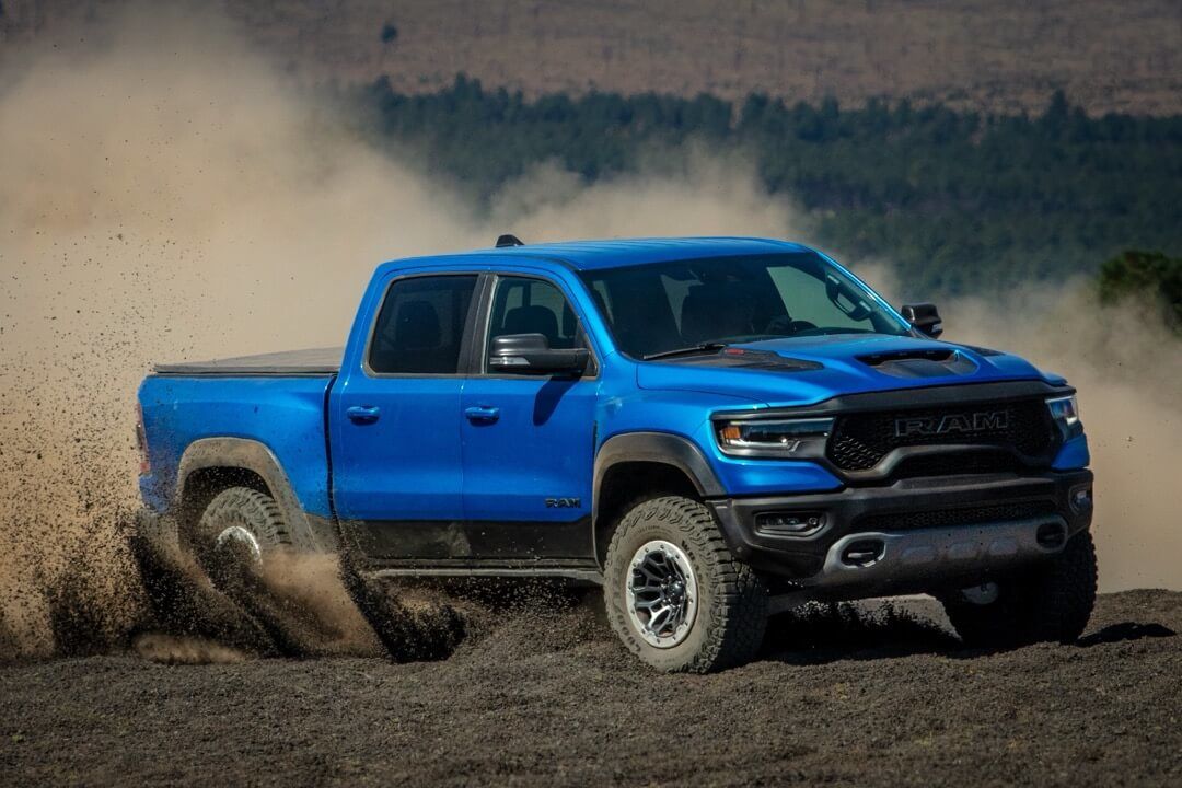 Front 3/4 view of the 2024 Ram 1500 TRX driving on dirt.