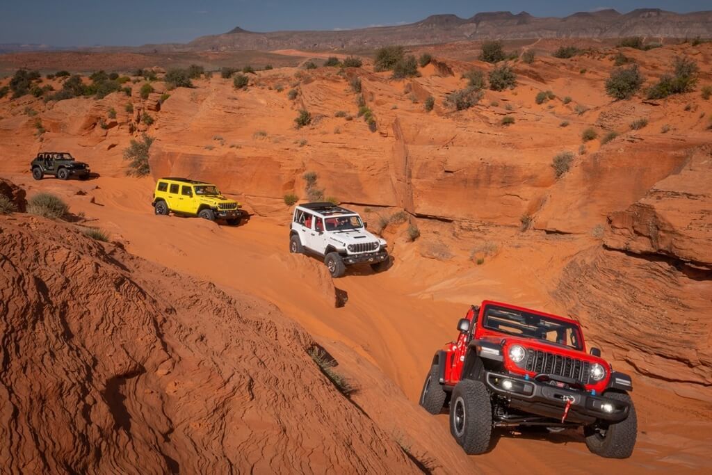 Four different versions of 2024 Jeep Wrangler following each other in a canyon.