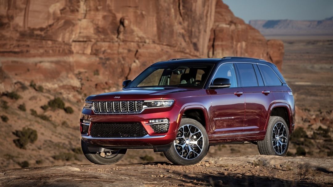 The 2025 Jeep Grand Cherokee, proudly parked atop a hill, ready to conquer any terrain.