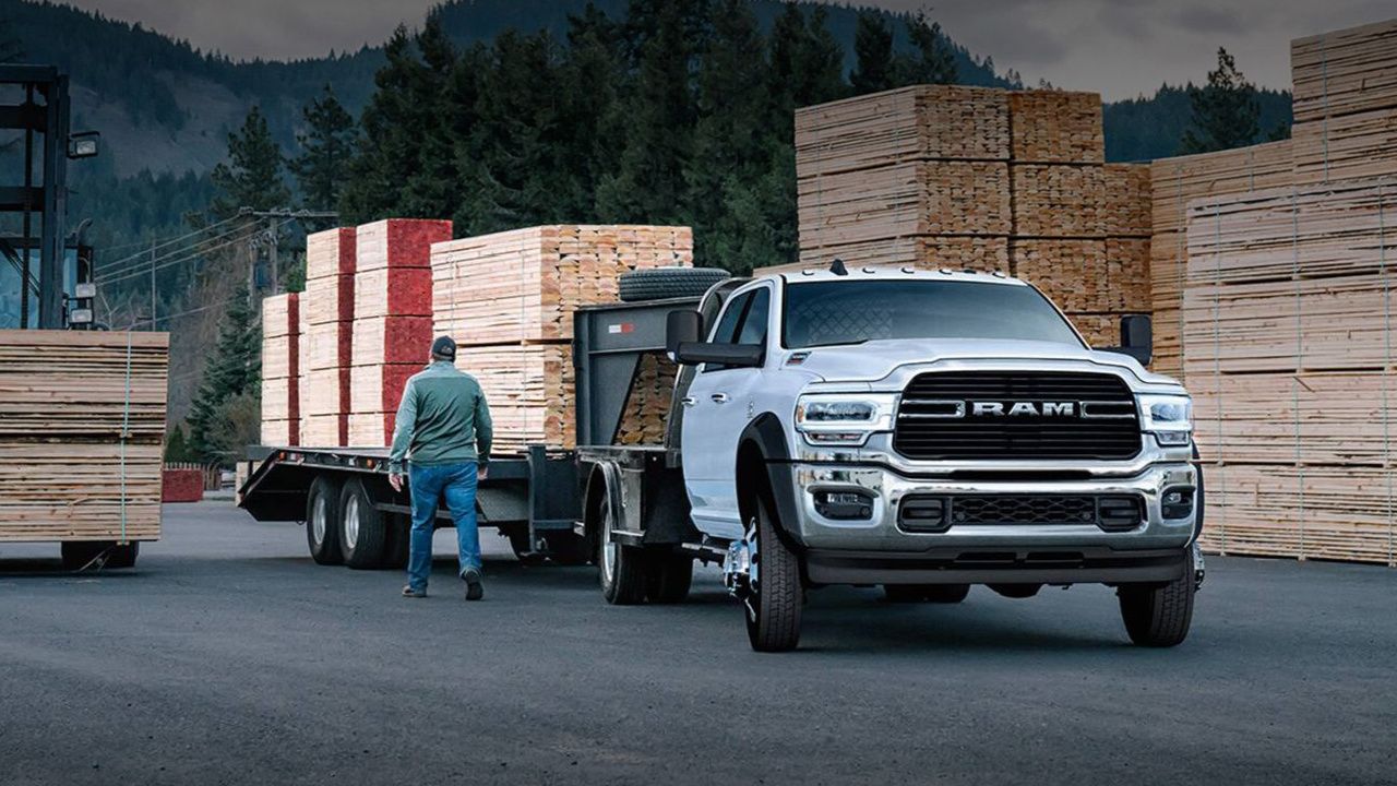 vue latérale avant d'un camion RAM 1500 2026 dans une cour à bois