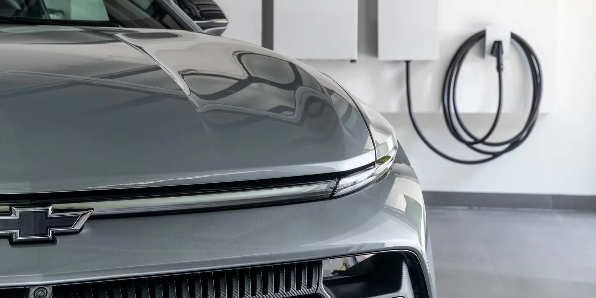 Face avant et phares DEL effil&eacute;s du Chevrolet Equinox EV 2026 pr&egrave;s d&rsquo;une borne r&eacute;sidentielle