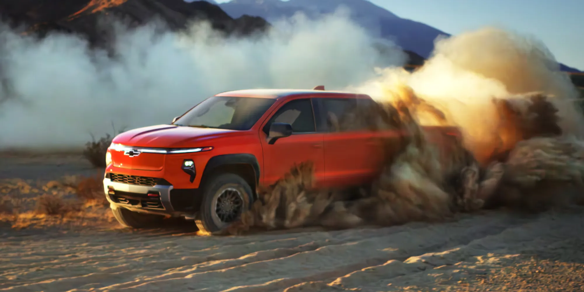 2026 Chevrolet Silverado EV kicking up dust while driving off-road.