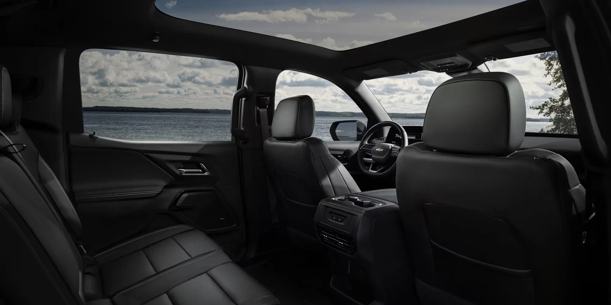 Chevrolet Silverado EV cabin with panoramic roof and water view.