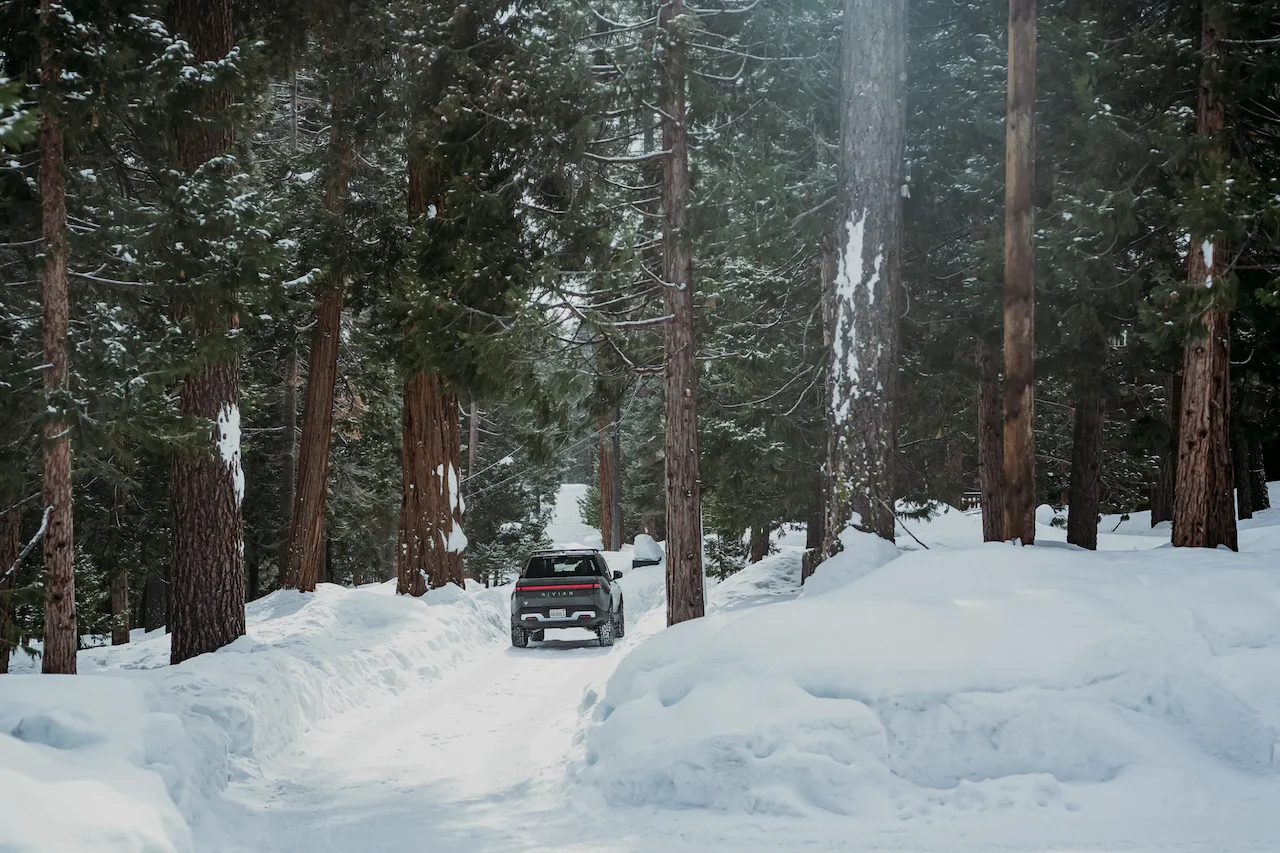2026 Rivian R1T in a snowy forest landscape.