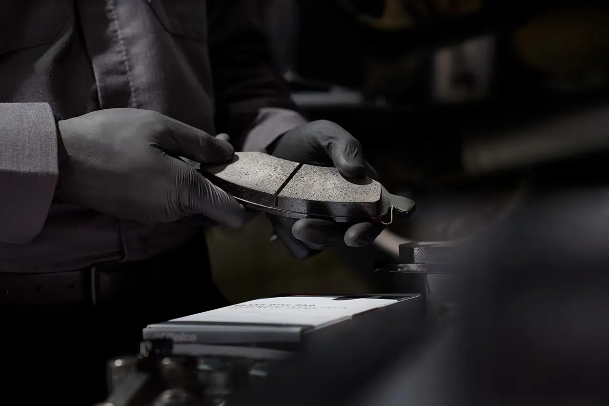Plaquettes de frein us&eacute;es en atelier, un signe m&eacute;canique indiquant qu'il est peut-&ecirc;tre temps de changer de voiture.