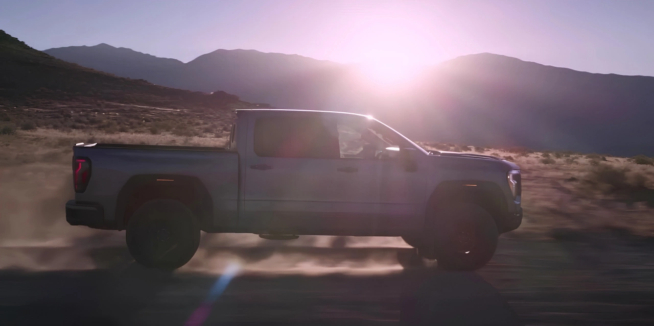 GMC Sierra 1500 2027 circulant hors route au coucher du soleil.