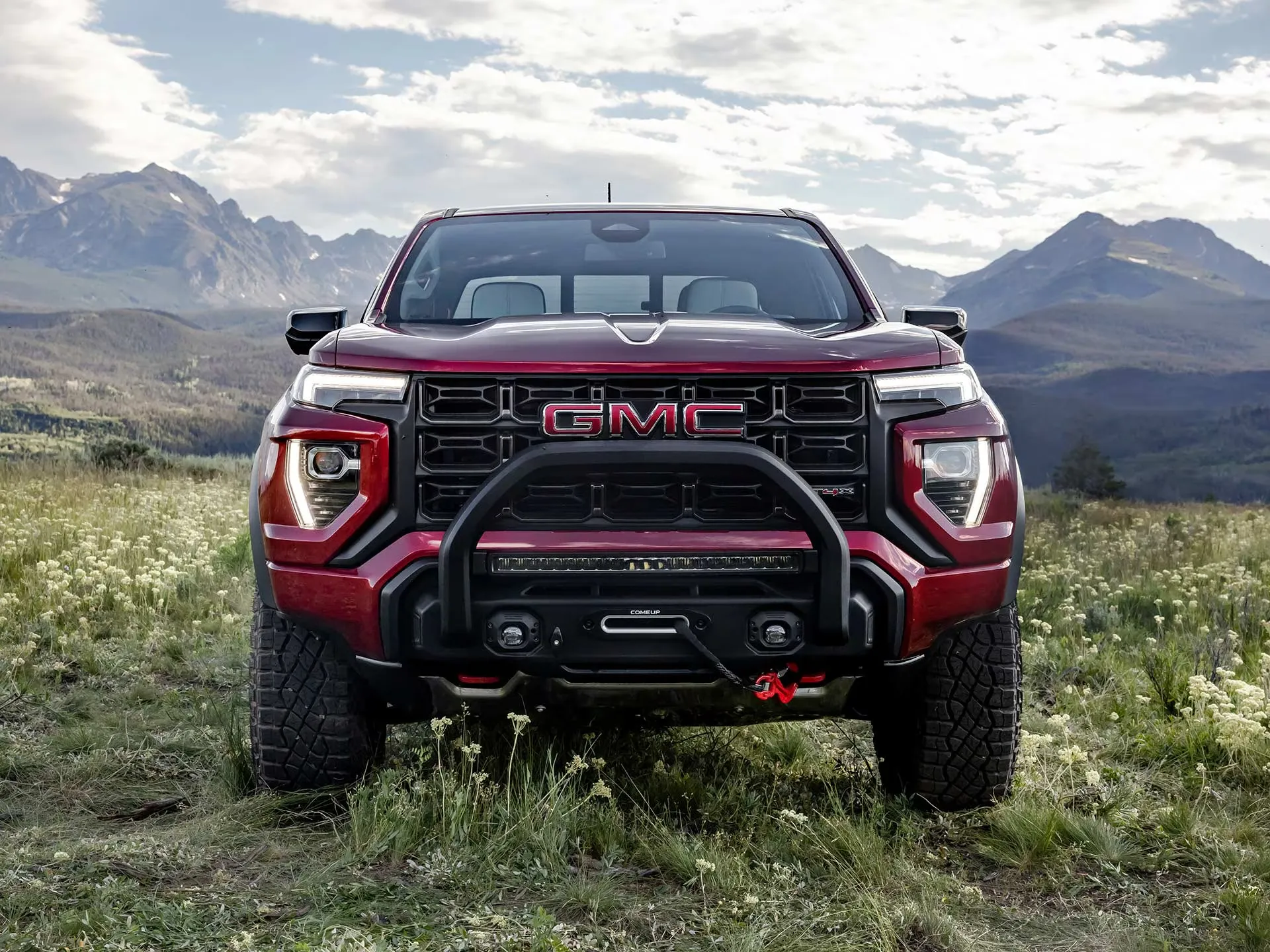 GMC Canyon AT4X 2026 rouge vu de face dans les montagnes.