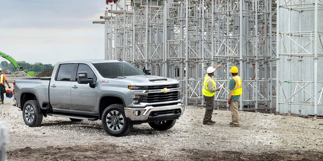 Chevrolet Silverado HD avec des travailleurs sur un chantier industriel.