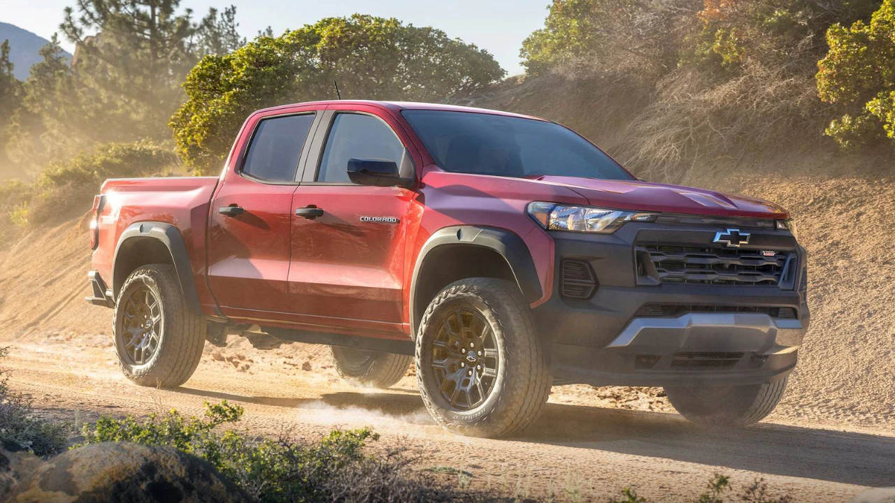 Chevrolet Colorado rouge roulant sur un chemin de chantier.