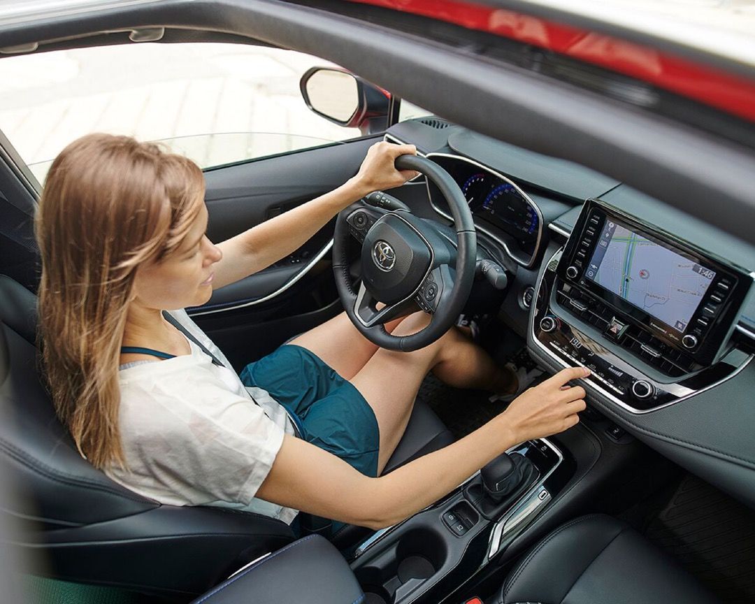 woman driving the 2022 Toyota Corolla XSE using on-board technologies