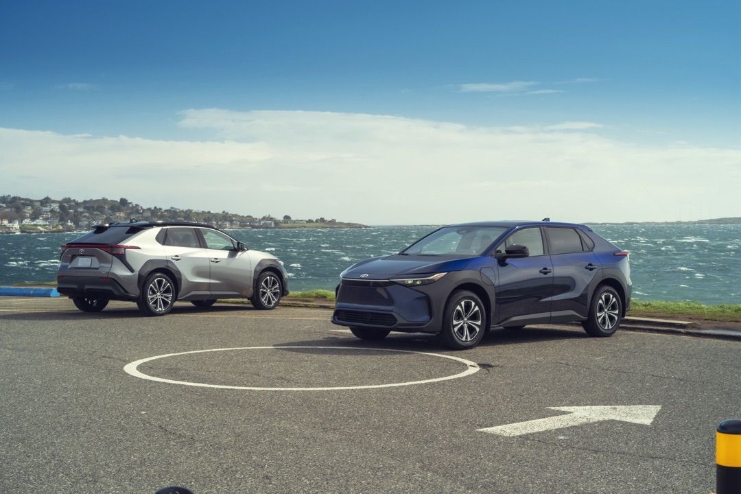 Deux Toyota BZ4X 2024 stationné devant la mer.