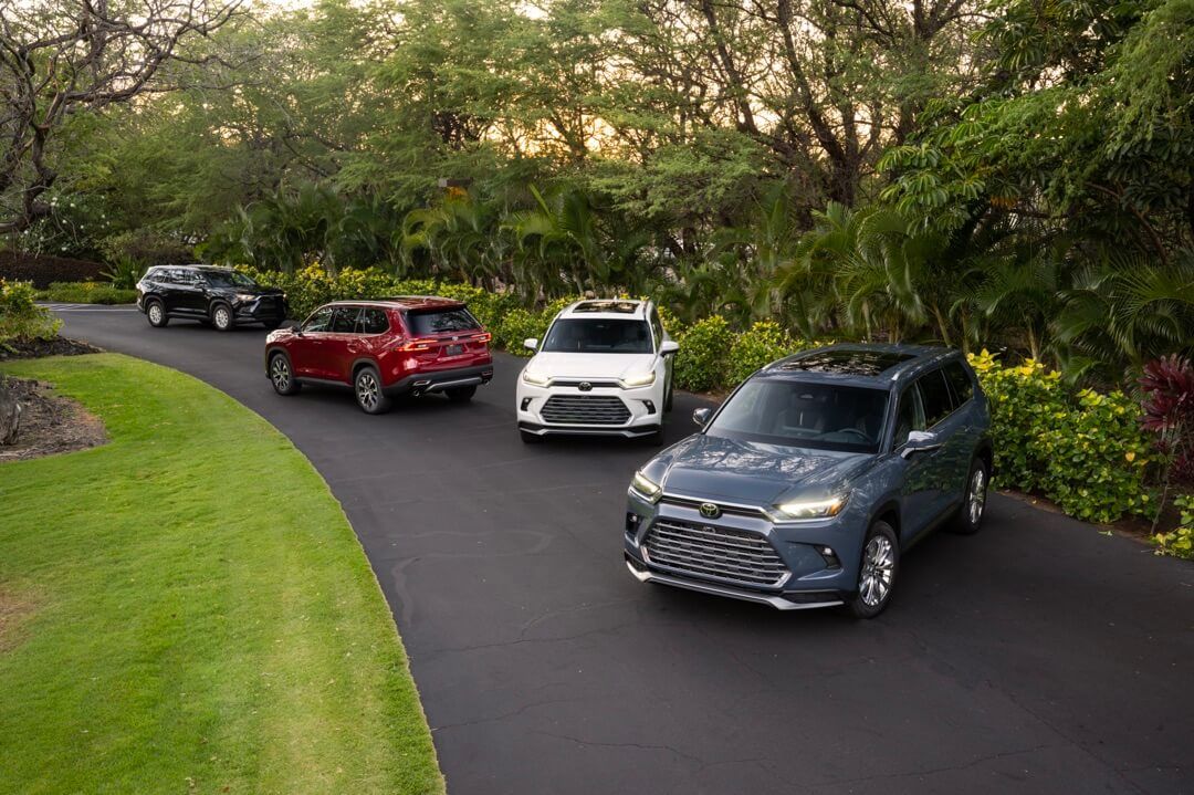 Four 2024 Toyota Grand Highlander SUVs parked on a road.