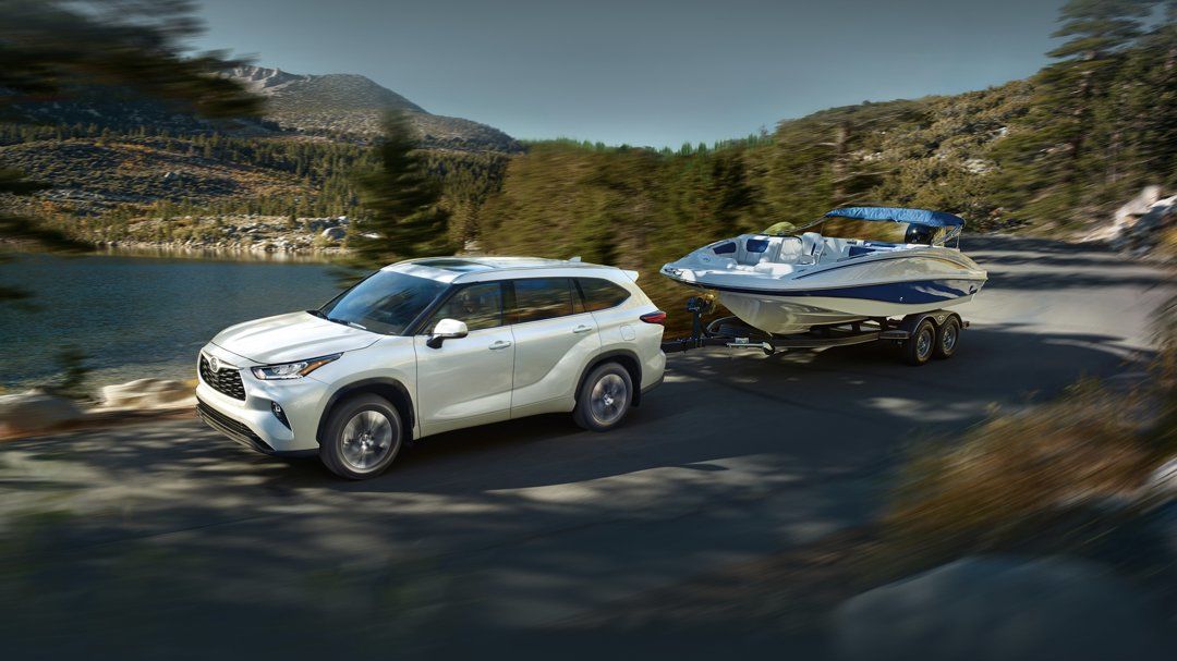 A 2024 Toyota Highlander towing a boat.