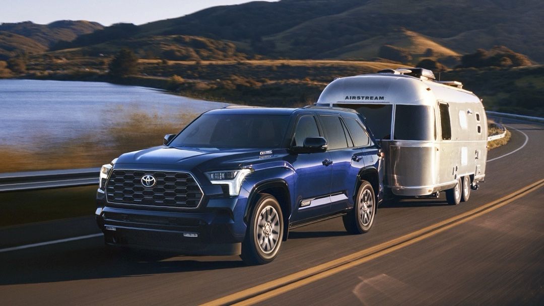 Le Toyota Sequoia 2024 qui tire une roulotte airstream sur la route dans une montée.