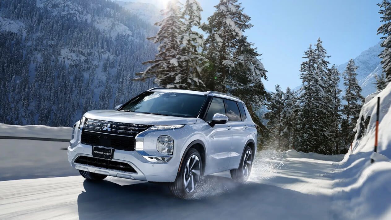 The Mitsubishi Outlander driving on a snowy mountain road.