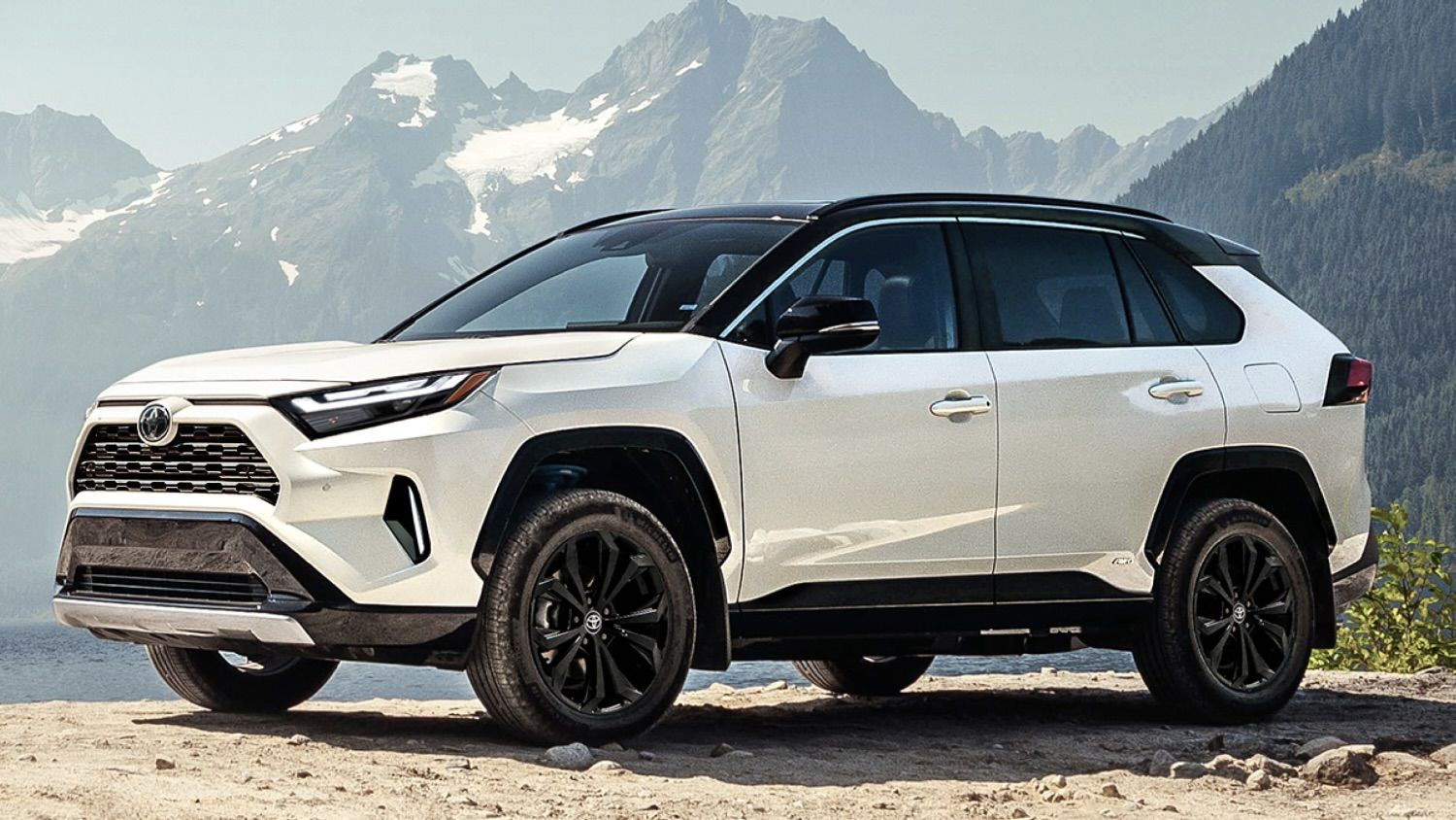 The Toyota RAV4 parked on a high point with mountains in the background.