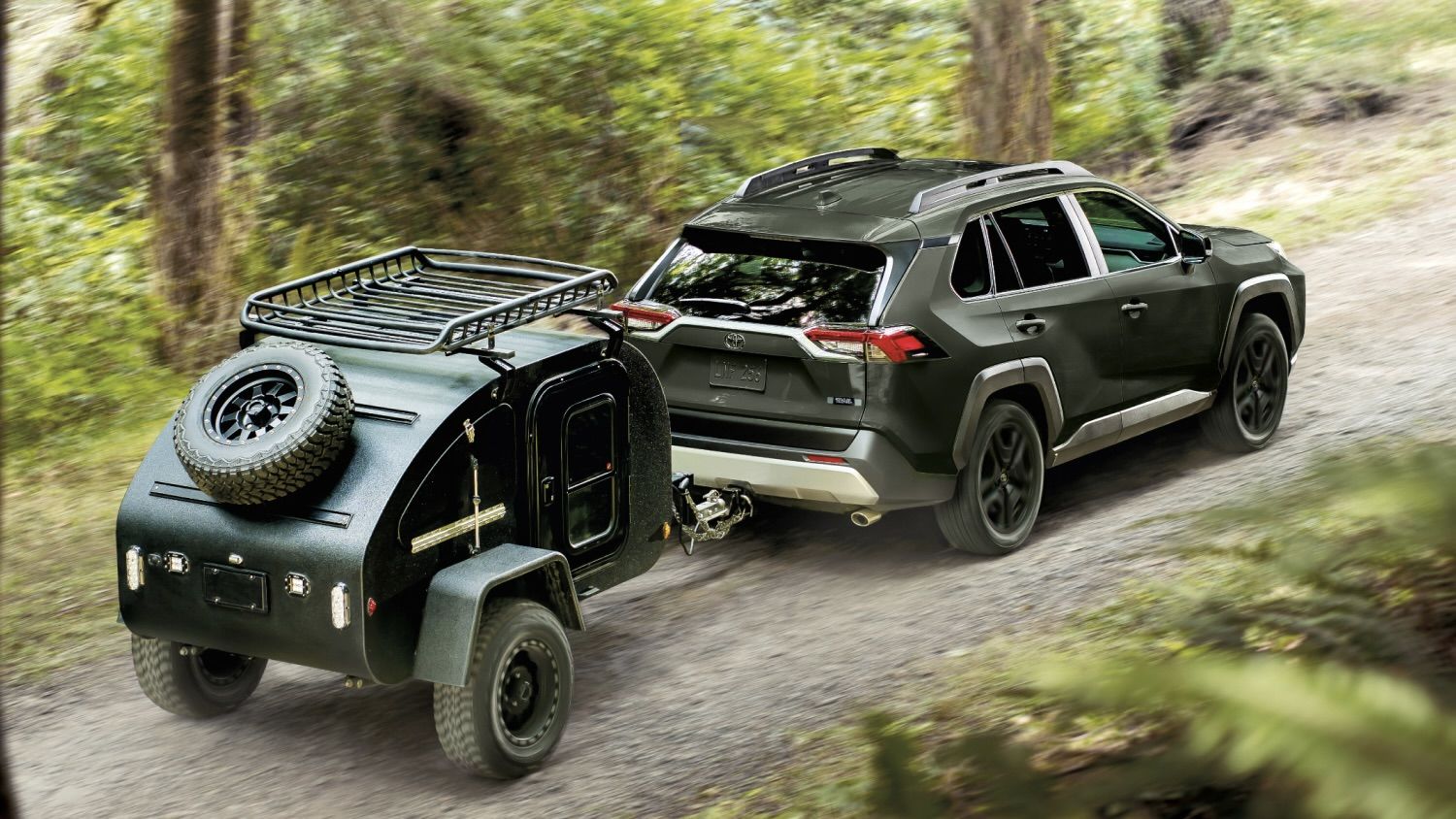 Le Toyota RAV4 2025 qui tire une petite remorque sur un chemin de gravel.