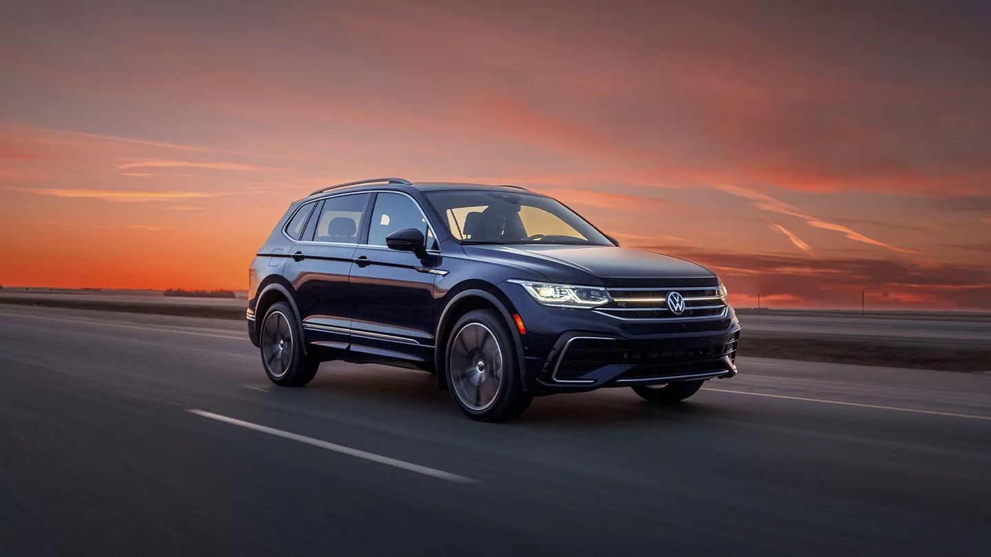 The Tiguan driving on a road at sunset.