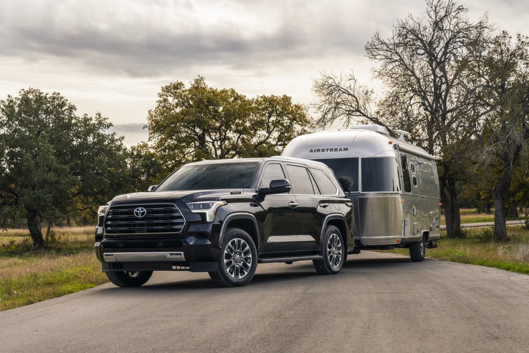 Front 3/4 view of the 2023 Toyota Sequoia SUV towing a trailer.