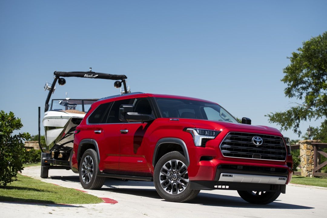 Front 3/4 view of the 2023 Toyota Sequoia SUV towing a deck boat.