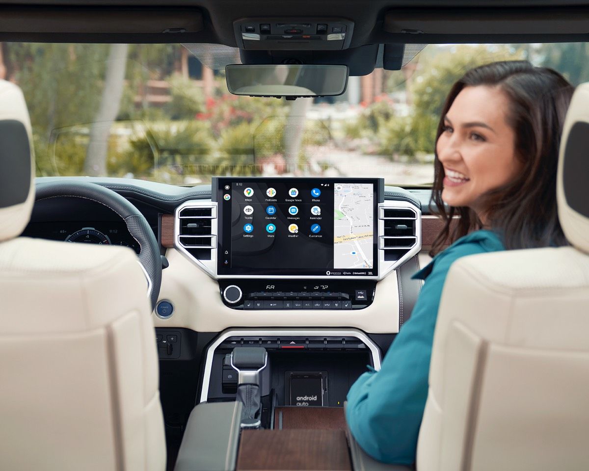Female passenger sitting at the front of the 2022 Toyota Tundra including its touchscreen showing navigation