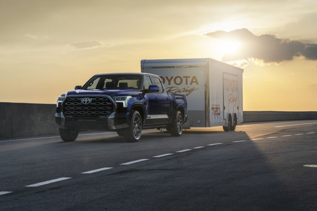 Le Toyota Tundra Platinum 2022 remorquant la caisse TOYOTA Racing TRD sur une grande route