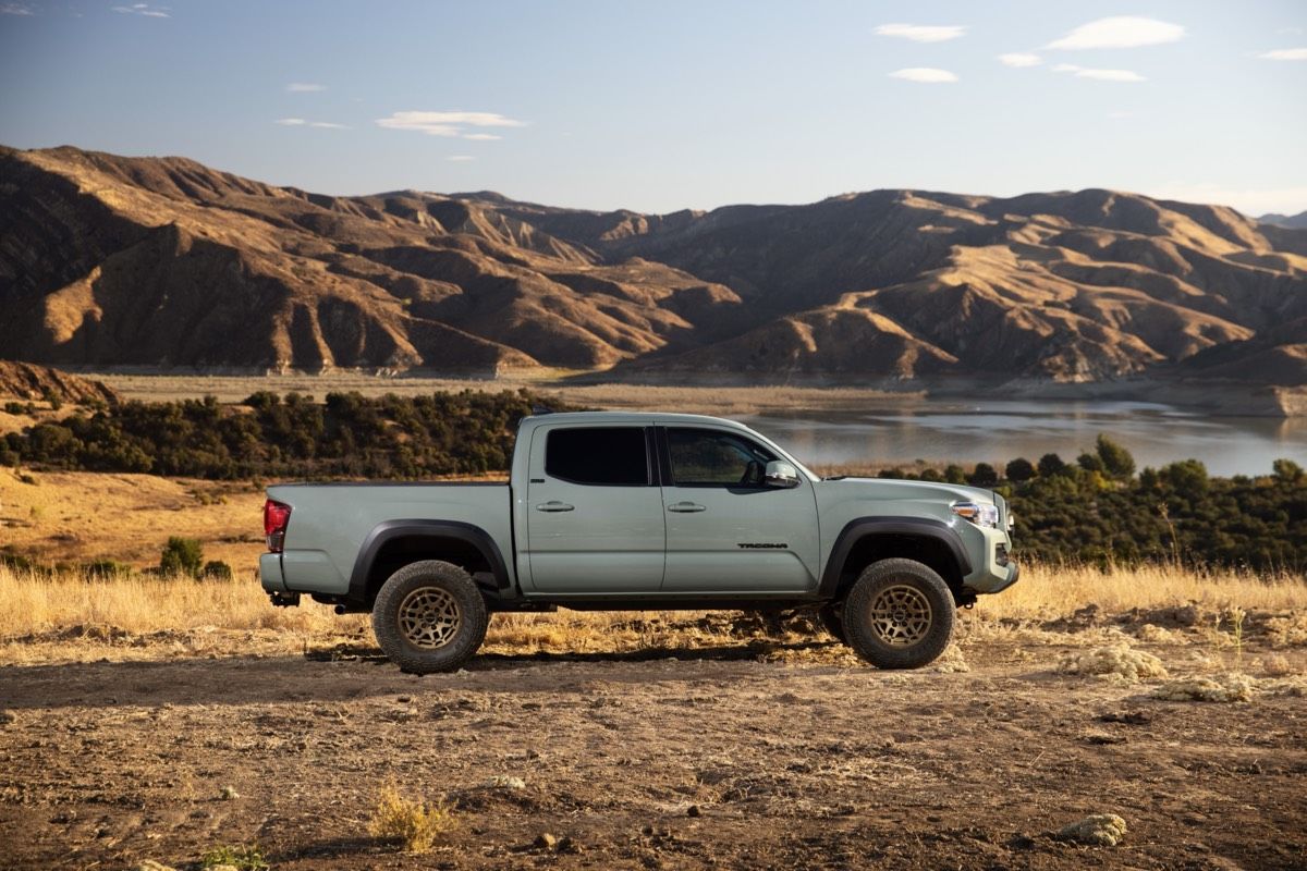 Vue latérale du Toyota Tacoma Trail 2022 de couleur Roche lunaire garé dans un désert