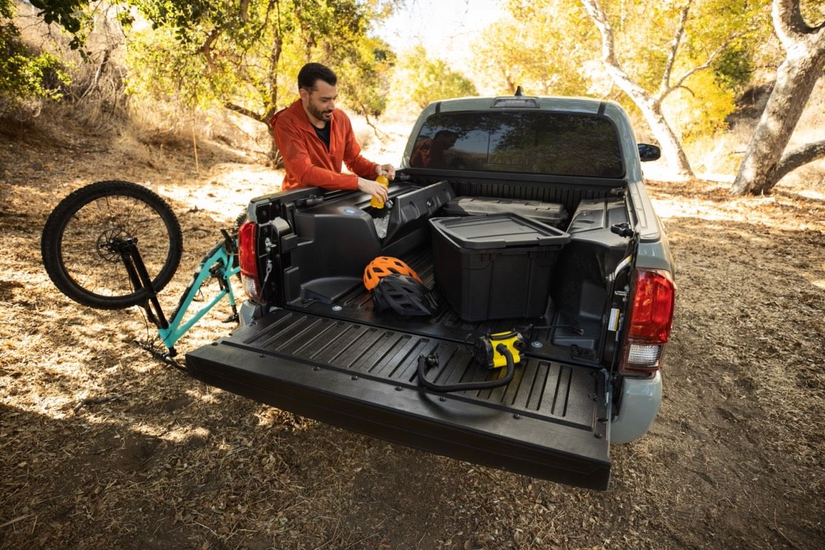 Man preparing his hiking equipment in the trunk of the 2022 Toyota Tacoma Trail 2022