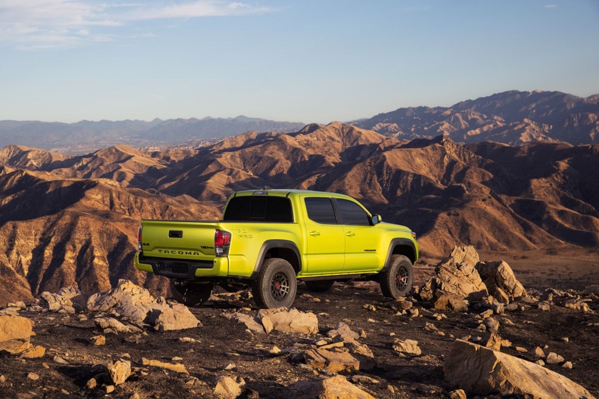 Rear 3/4 view of the 2022 Army Green Toyota Tacoma Trail parked on top of a mountain