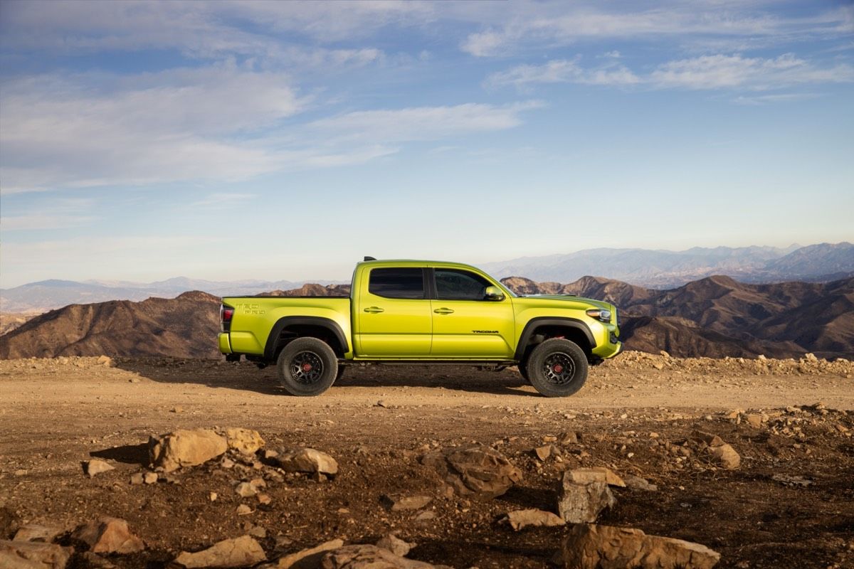 Vue latérale du Toyota Tacoma Trail 2022 de couleur Vert Kaki garé dans un désert
