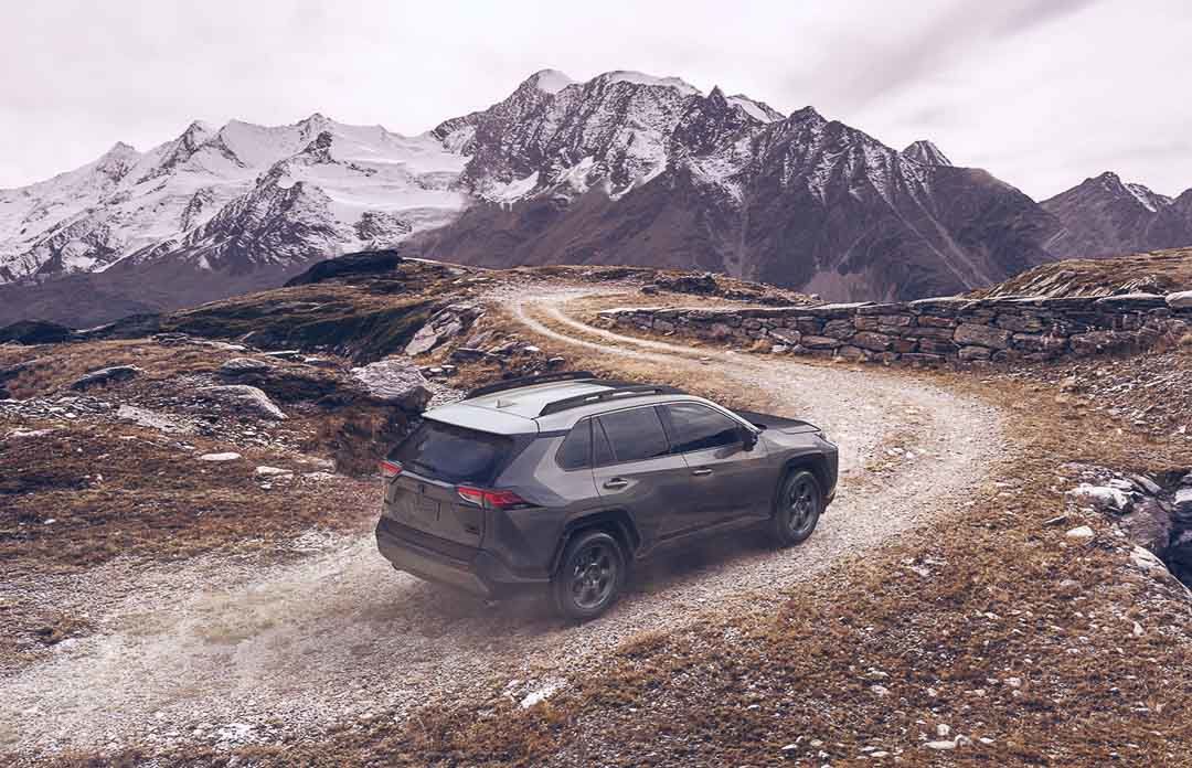 The 2021 Toyota RAV4 driving on a dirt road towards the Rockies
