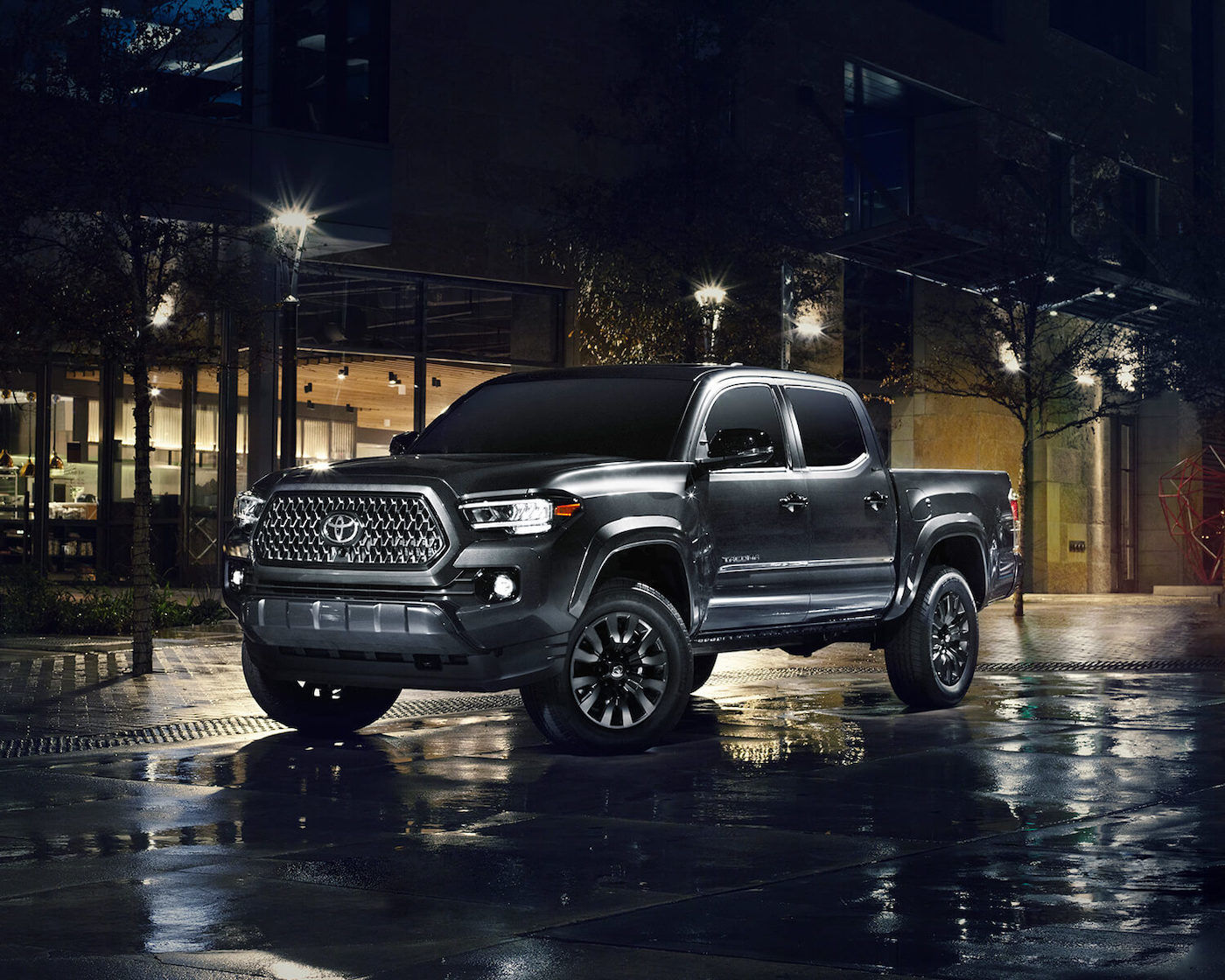 Front 3/4 view of a 2022 Toyota Tacoma Nightshade with its black trims parked in town